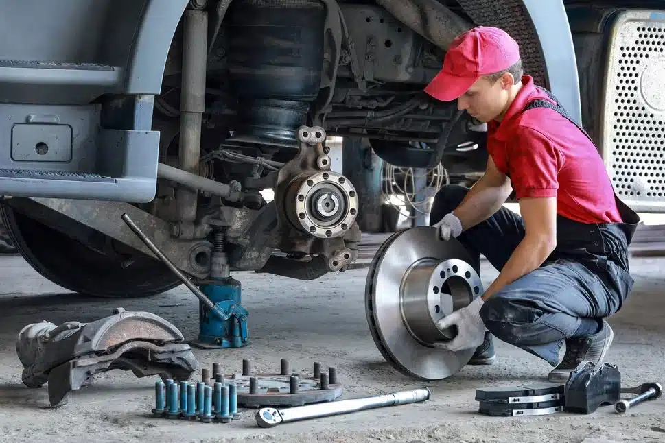 fleet mechanic working on a truck changing brakes and using fleetpal to log all the repairs done